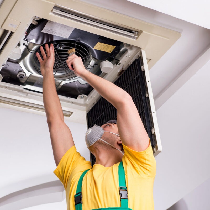 Young-Repairman-Repairing-Ceiling-Air-Conditioning-Unit