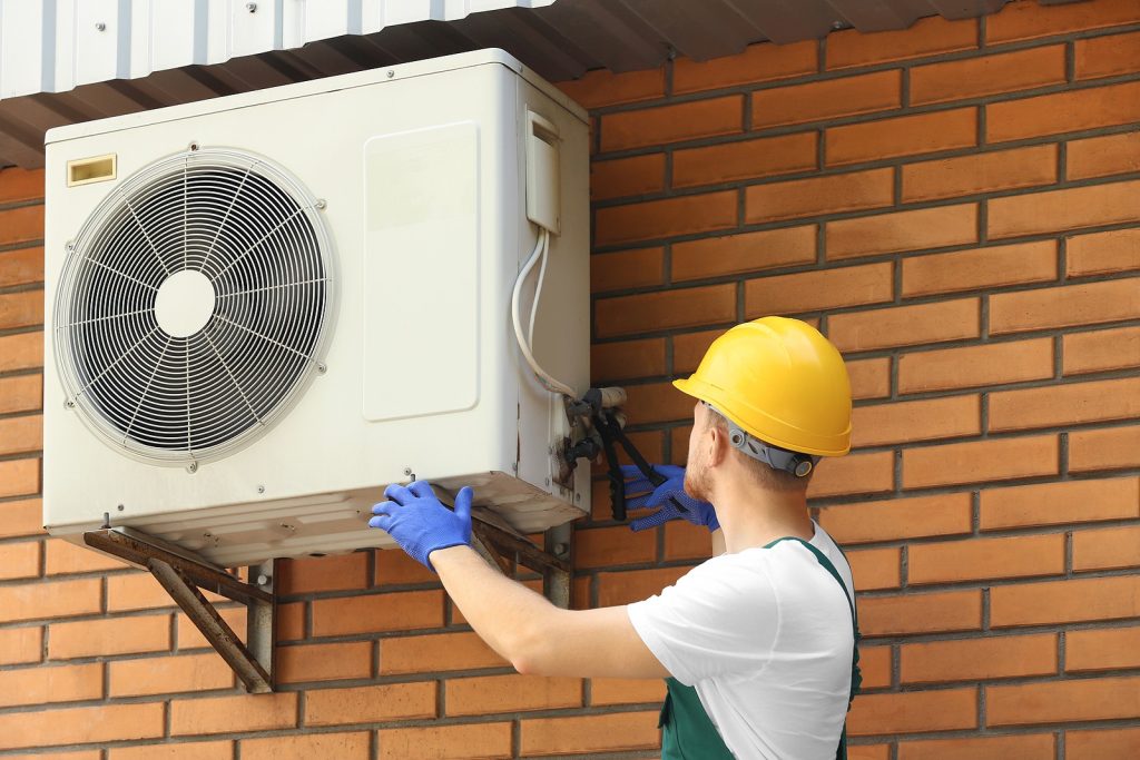 Professional-HVAC-Technician-Repairing-Repairing-Wall-Mounted-Air-Conditioner-Outdoors